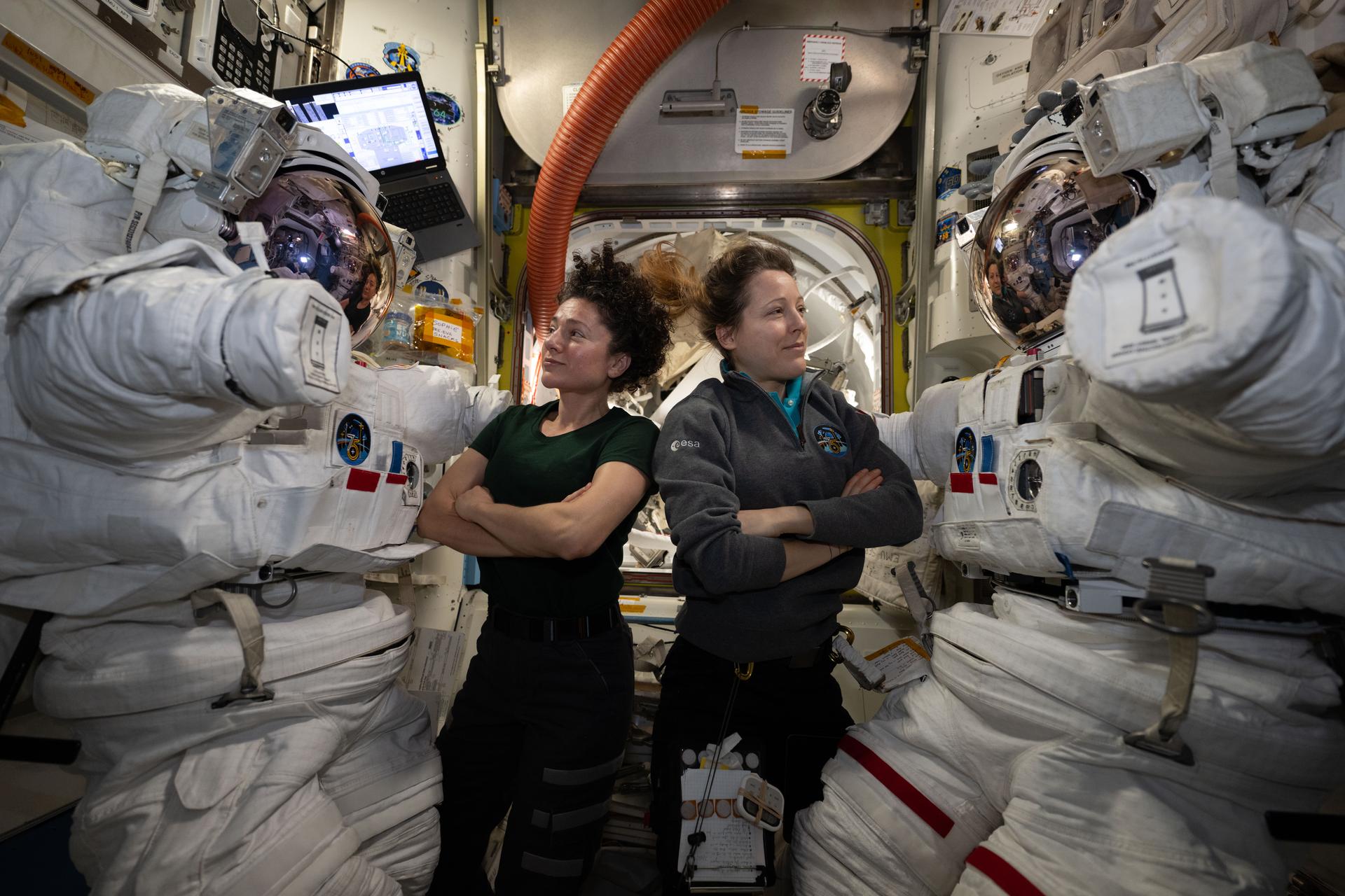 From left, astronauts Jessica Meir of NASA and Sophie Adenot of ESA (European Space Agency) pose for a portrait inside the International Space Station’s Quest airlock while configuring spacesuits the day before they conducted a spacewalk together. Meir and Adenot spent six hours and 49 minutes the next day installing a spacecraft navigation aid, swabbing the station’s exterior for microorganisms, and preparing a cosmic particle detector for future upgrades outside the International Space Station.