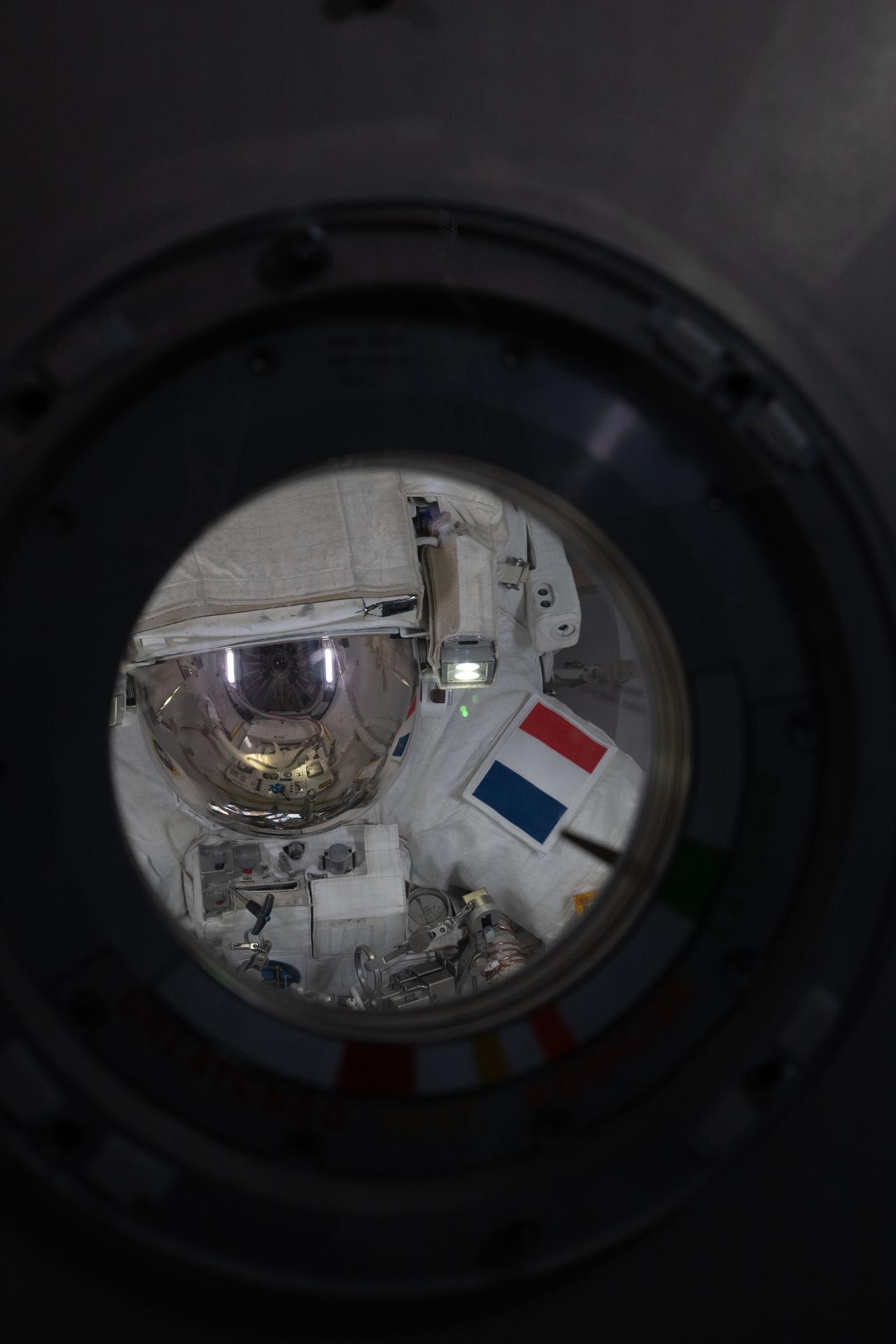 ESA (European Space Agency) astronaut Sophie Adenot, with her spacesuit’s gold‑plated helmet visor down and wearing a patch representing her home country of France, is pictured inside the Quest airlock after the completion of a six‑hour and 49‑minute spacewalk. Adenot, along with station commander Jessica Meir of NASA (out of frame), installed a spacecraft navigation aid, swabbed the station’s exterior for microorganisms, and prepared a cosmic particle detector for future upgrades outside the International Space Station.