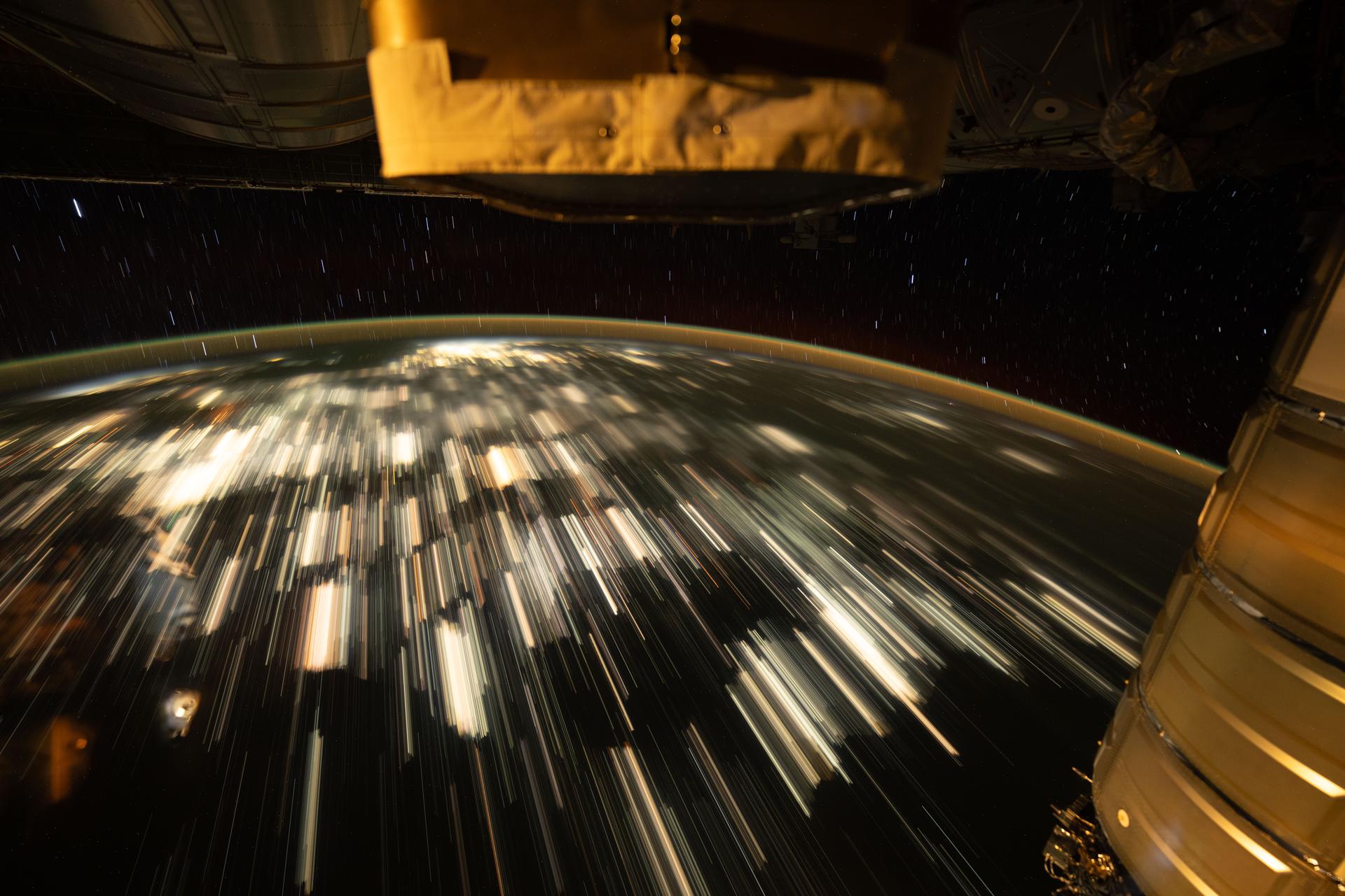 This long-duration image shows star trails above Earth and the city lights of eastern China stretching below the International Space Station as it orbited 262 miles above Earth.