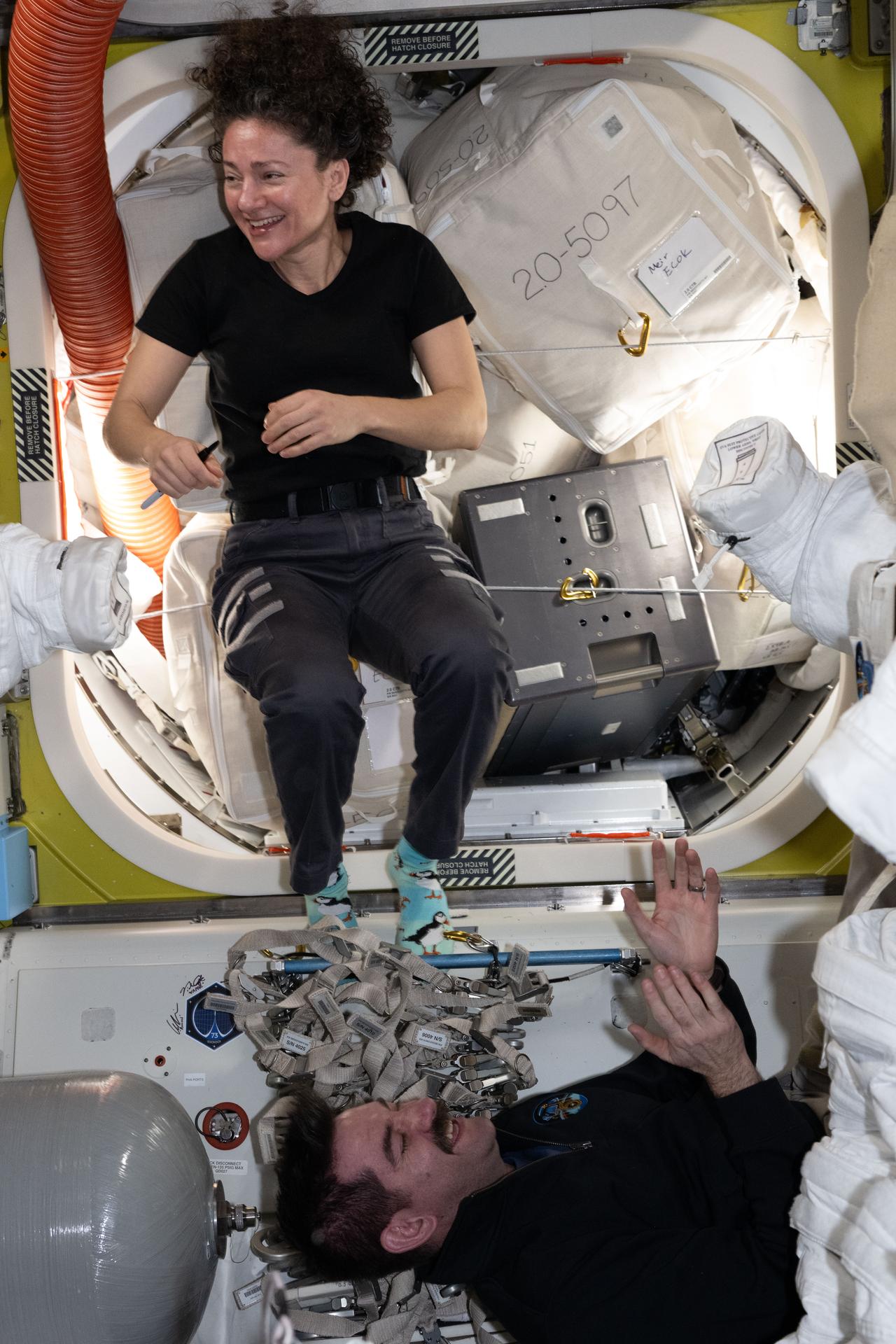 iss075e0144601 (Sept. 23, 2026) --- NASA astronauts Jessica Meir and Jack Hathaway, station commander and flight engineer respectively for the Expedition 75 crew, are pictured relaxing inside the International Space Station's Quest airlock at the end of their shift. Credit: NASA/Anil Menon