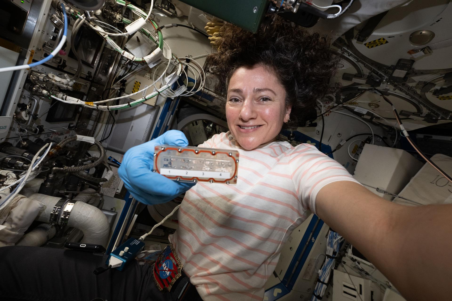 NASA astronaut and Expedition 75 commander Jessica Meir shows off a tissue chamber that houses samples for viewing inside the Nikon Experimentation Microscope in Orbit (NEMO). Located inside the International Space Station's Destiny laboratory module, NEMO enables automated imaging of growing cells to study microgravity’s effects on disease, tissue development, and drug responses.