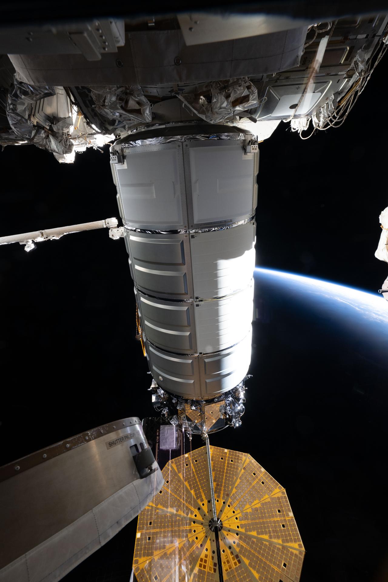 Northrop Grumman's Cygnus XL cargo spacecraft is pictured berthed to the International Space Station's Earth-facing port on the Unity module. At the bottom is one of two cymbal‑shaped UltraFlex solar arrays attached to Cygnus XL's service module, which provides navigation, power, and propulsion for the spacecraft. The orbital outpost was soaring 257 miles above the Arabian Sea, heading into an orbital sunset at the time of this photograph.