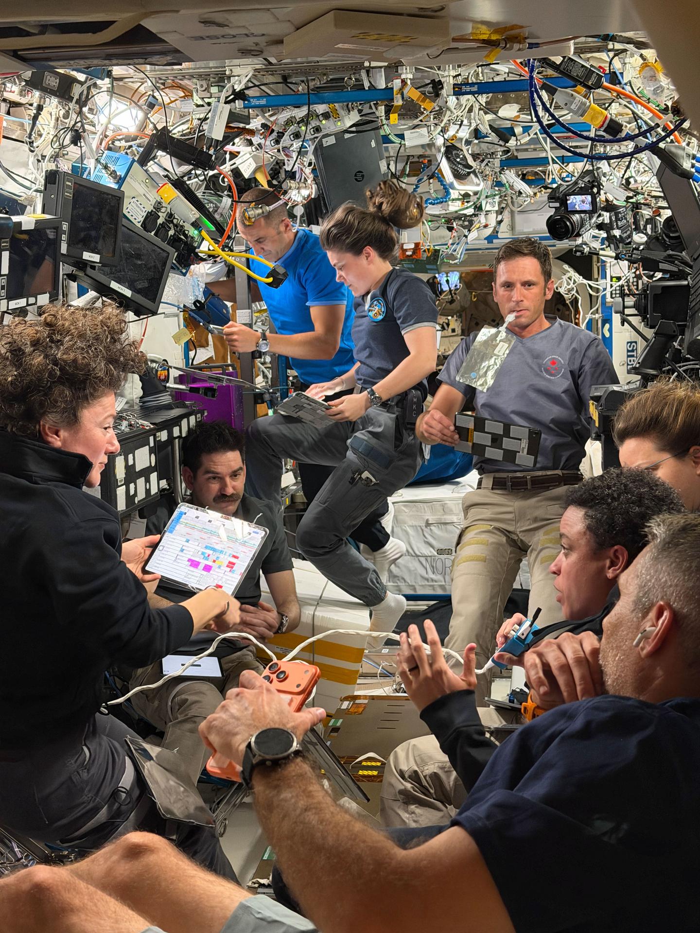 Fotomural Expedition 75 crew members gather for a daily planning conference