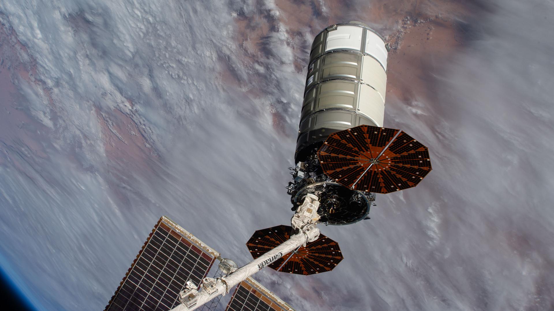 Northrop Grumman’s Cygnus XL cargo spacecraft is pictured in the grip of the Canadarm2 robotic arm moments before its release into Earth orbit after a nearly six‑month stay attached to the International Space Station’s Unity module. The orbital outpost was soaring 263 miles above the Indian Ocean, off the coast of Madagascar, at the time of this photograph.