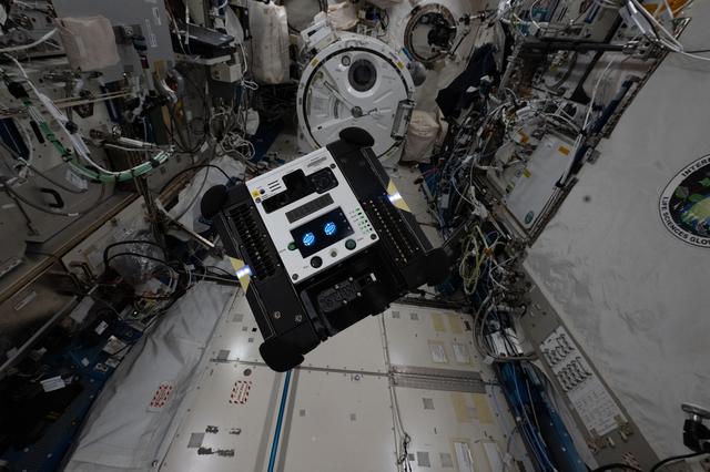 An Astrobee autonomously maneuvers inside the International Space Station