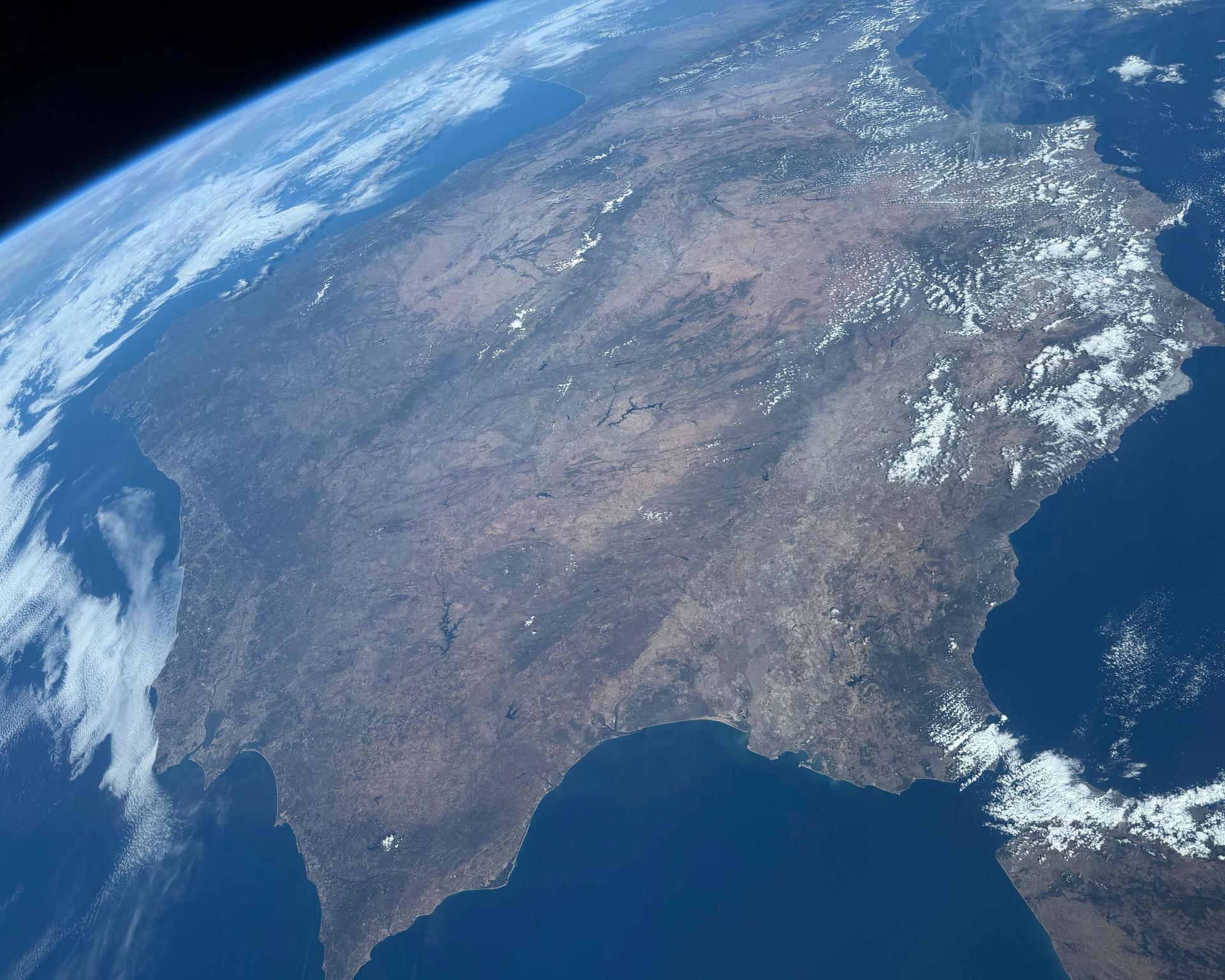 The Iberian Peninsula, comprised mainly of Spain and Portugal and bounded by the Pyrenees to the northeast (top) and the Strait of Gibraltar to the south (bottom left), is pictured from the International Space Station while orbiting above northern Africa. The microstate of Andorra, the British Overseas Territory of Gibraltar, and a small portion of southern France are also part of this geographical landmass in southwestern Europe.