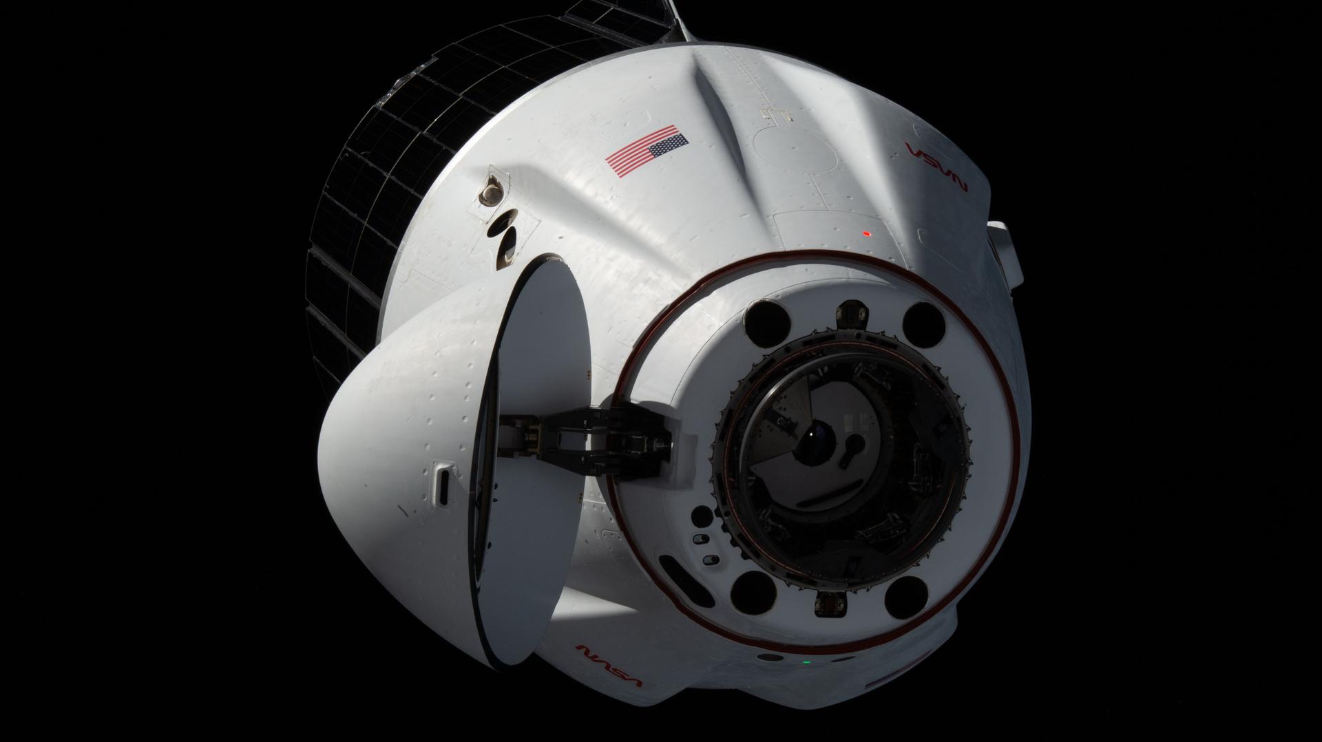 A SpaceX Dragon spacecraft carrying more than 6,300 pounds of science and supplies for the Expedition 75 crew, along with a pair of roll-out solar arrays to augment the International Space Station's power generation system, approaches the orbital outpost for an automated docking to the space-facing port on the Harmony module.