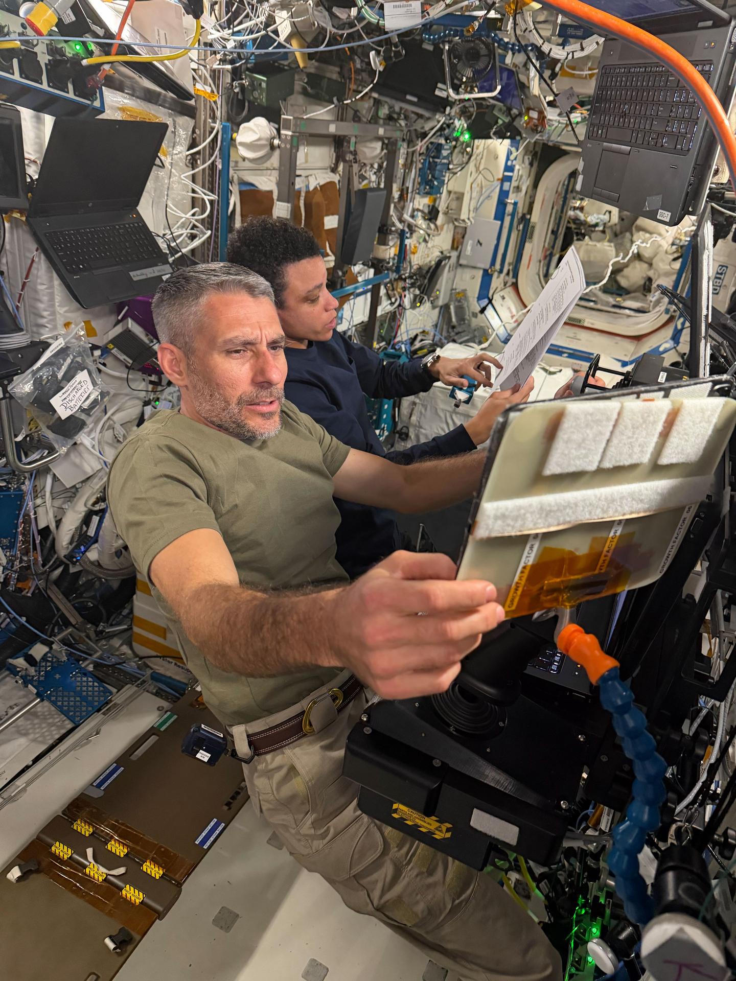 Expedition 75 flight engineers Luke Delaney and Jessica Watkins, both NASA astronauts, review and practice Canadarm2 robotic arm maneuvers at the robotics workstation inside the International Space Station’s Destiny laboratory module. Delaney and Watkins trained to support an upcoming spacewalk with Expedition 75 flight engineers Anil Menon of NASA and Joshua Kutryk of the Canadian Space Agency (CSA) to install a roll-out solar array on the orbital outpost’s truss structure.