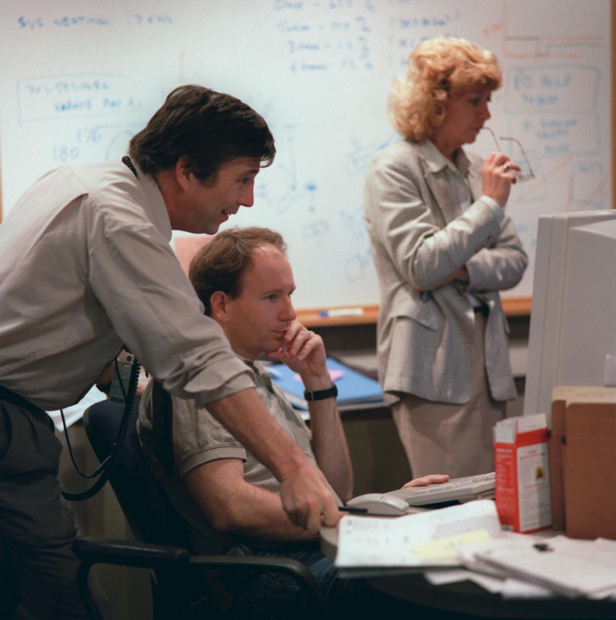 JSC2000-01451 (16 February 2000)---  Three SRTM personnel support the STS-99 at and near the Crew Interface Console (CIC) in the Payload Operations Control Center (POCC) at JSC's Mission Control Center.  From left are Mike Kobrick, Ian  Joughin and Diane Ainsworth.
