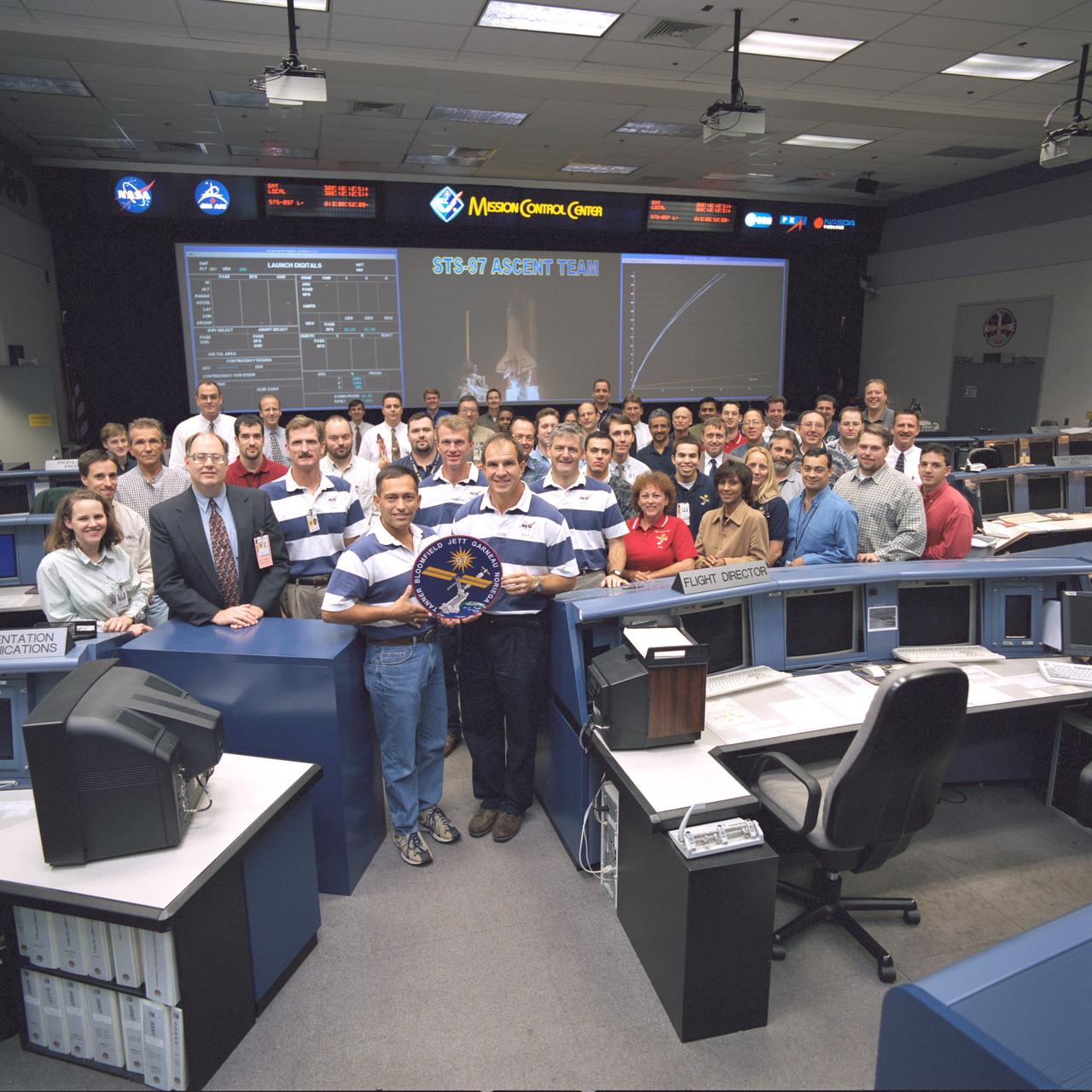 JSC2000-07294 (20 November 2000) --- The 40-odd flight controllers assigned to the STS-97 ascent team and some special guests pose for a group portrait in the shuttle flight control room in Houston's Mission Control Center (JSC). The five guests attired in the blue and white shirts are the flight crew members for the STS-97 crew, scheduled to be launched from Florida on the last day of this month. The astronauts are, from the left, Joseph R. Tanner, Carlos I. Noriega, Brent W. Jett, Jr., Michael J. Bloomfield and Marc Garneau, who represents the Canadian Space Agency (CSA). Ascent shift flight director Wayne Hale stands next to Tanner.