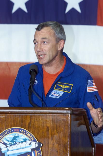 JSC2000-E-23451 (21 September 2000) --- Astronaut Terrence W. Wilcutt, STS-106 mission commander, addresses the crowd that visited Ellington Field's Hangar 990 to welcome home the STS-106 astronauts and cosmonauts.  Seated on the dais, from the left, are astronaut Edward T. Lu, cosmonaut Yuri I. Malenchenko, and astronauts Terrence W. Wilcutt and Daniel C. Burbank.  Not in the frame are astronaut Richard A. Mastracchio and cosmonaut Boris V. Morukov. The seven-man crew landed approximately 24 hours earlier in Florida, wrapping up a 4.9 million-mile mission in which more than three tons of equipment were delivered to the international outpost.