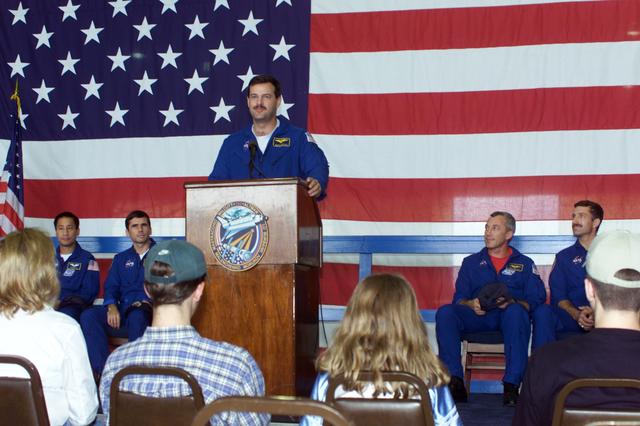 JSC2000-E-23454 (21 September 2000) --- Astronaut Scott D. Altman, STS-106 pilot, addresses the crowd that visited Ellington Field's Hangar 990 to welcome home the STS-106 astronauts and cosmonauts.  Seated on the dais, from the left, are astronaut Edward T. Lu,  cosmonaut Yuri I. Malenchenko, astronaut Terrence W. Wilcutt and Daniel C. Burbank.  Not in the frame are astronaut Richard A. Mastracchio and cosmonaut Boris V. Morukov. The seven-man crew landed approximately 24 hours earlier in Florida, wrapping up a 4.9 million-mile mission in which more than three tons of equipment were delivered to the international outpost.