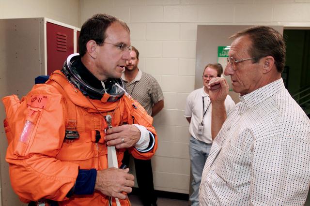 JSC2000-E-23528 (October 2000) --- Astronaut Michael J. Bloomfield, left, discusses his launch and entry suit with USA technician Bill Todd prior to a training session in the Johnson Space Center's Systems Integration Facility.