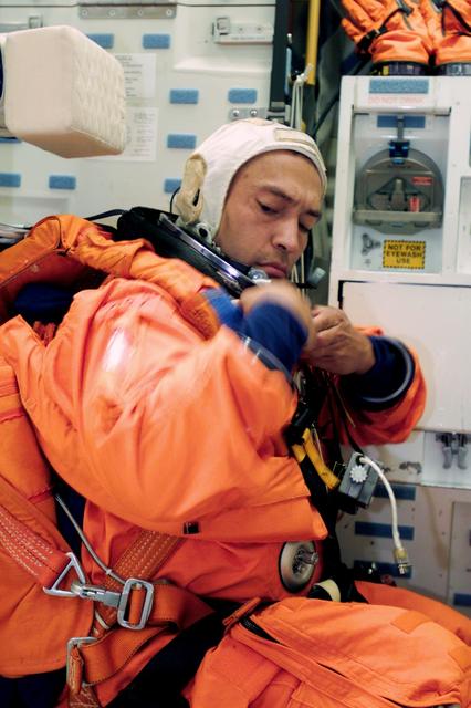 Photographic documentation of the STS-97 preflight training which occurred in Building 9 Crew Compartment Trainer II (CCTII). Views include: Astronaut Brent W. Jett (center), STS-97 mission commander, shares a light moment with two of the mission specialists on his crew, astronauts Joseph R. Tanner (left) and Carlos I. Noriega. The three are about to don training versions of the orange Launch and entry suit (LES) prior to a dry run of countdown procedures (23524). Astronaut Joseph R. Tanner (left), mission specialist, helps astronaut Michael J. Bloomfield, pilot, with final touches on his suit-donning process as USA suit technicians Bill Todd (standing) and Brad Milling look on (23525). Astronaut Carlos I. Noriega, attired in a blue thermal undergarment, and USA suit technician Mike Birkenseher help astronaut Brent W. Jett, STS-97 mission commander, with final touches of suit donning (23526). Astronaut Marc Garneau, mission specialist representing the Canadian Space Agency (CSA), looks on as two crew mates assist him with final touches of suit-donning prior to a training session in the Johnson Space Center's Systems Integration Facility. Helping out are astronauts Carlos I. Noriega (left) and Joseph R. Tanner, mission specialists (23527). Astronaut Michael J. Bloomfield, left, discusses his launch and entry suit with USA technician Bill Todd prior to a training session (23528). Astronaut Joseph R. Tanner lends a helping hand to astronaut Carlos I. Noriega as the two STS-97 mission specialists prepare for a dry run going over launch procedures in a nearby simulator (23529). Astronaut Joseph R. Tanner receives a helping hand from astronaut Carlos I. Noriega as the two STS-97 mission specialists don training versions of their pressure ascent and entry garments (23530). Noriega adjusts his LES while in the CCTII middeck mock-up (23531).