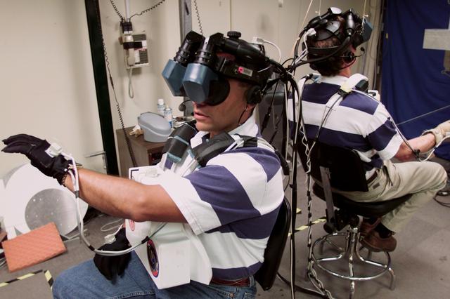JSC2000-E-26587 (October 2000) --- The two assigned space-walking astronauts for the STS-97 mission train for their scheduled extravehicular activity (EVA) in the virtual reality laboratory at the Johnson Space Center (JSC). They are astronauts Carlos I. Noriega (left) and Joseph R. Tanner, both mission specialists.