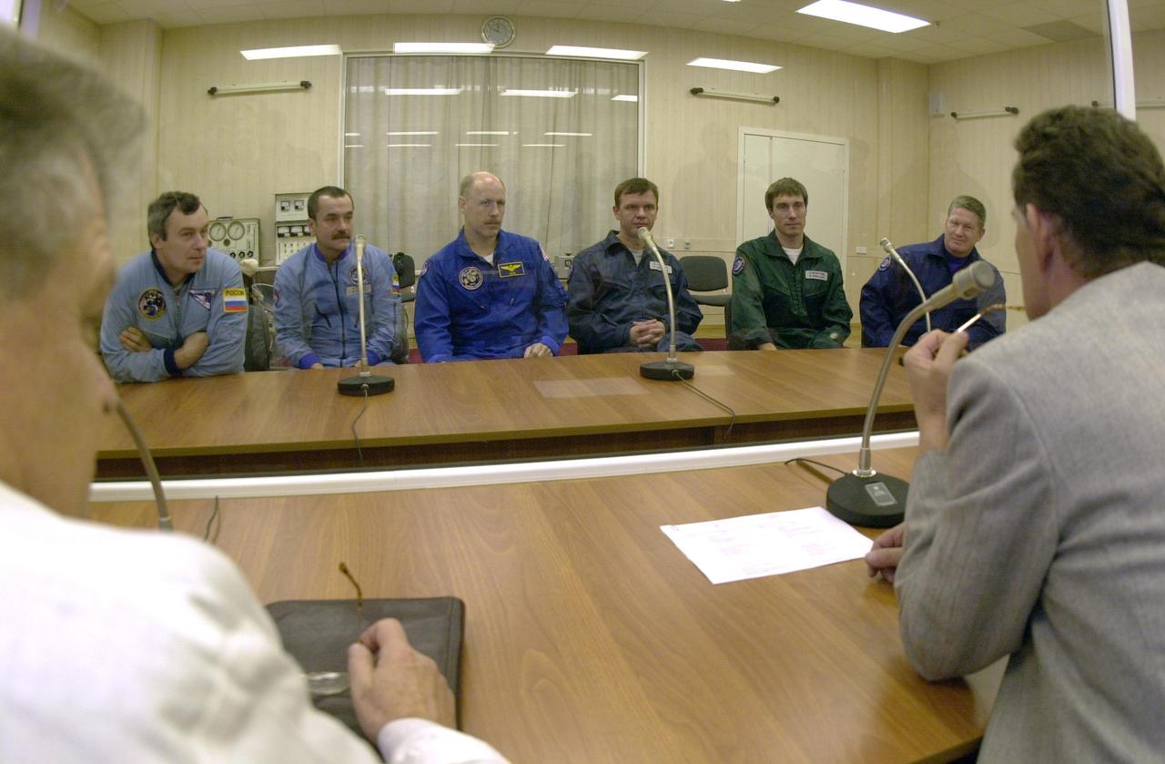 JSC2000-E-27080 (20 October 2000) ---  In background, from left, Vladimir N. Dezhurov, Mikhail Turin, Kenneth D. Bowersox, Yuri P. Gidzenko, Sergei K. Krikalev and William M. (Bill) Shepherd, the backup and prime crew members for Expedition One, during conference prior to simulation at Baikonur complex in Kazakhstan.