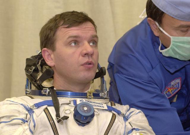 JSC2000-E-27084 (20 October 2000) --- Expedition 1 Soyuz commander Yuri P. Gidzenko, wearing a Sokol suit, gets help with his suit before entering the Soyuz spacecraft at Baikonur.  Out of frame are Expedition 1 commander William M. (Bill) Shepherd and flight engineer Sergei K. Krikalev.