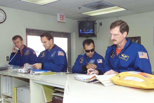 JSC2000-E-29119 (27 November 2000) --- Performing final tasks prior to leaving Ellington Field for Florida are four members of the STS-97 crew. From the left are astronauts Brent W. Jett, Jr., Michael J. Bloomfield, Carlos I. Noriega and Joseph R. Tanner. Marc Garneau, who represents the Canadian Space Agency (CSA), is not pictured. Launch from Florida's Kennedy Space Center (KSC) is scheduled for November 30.