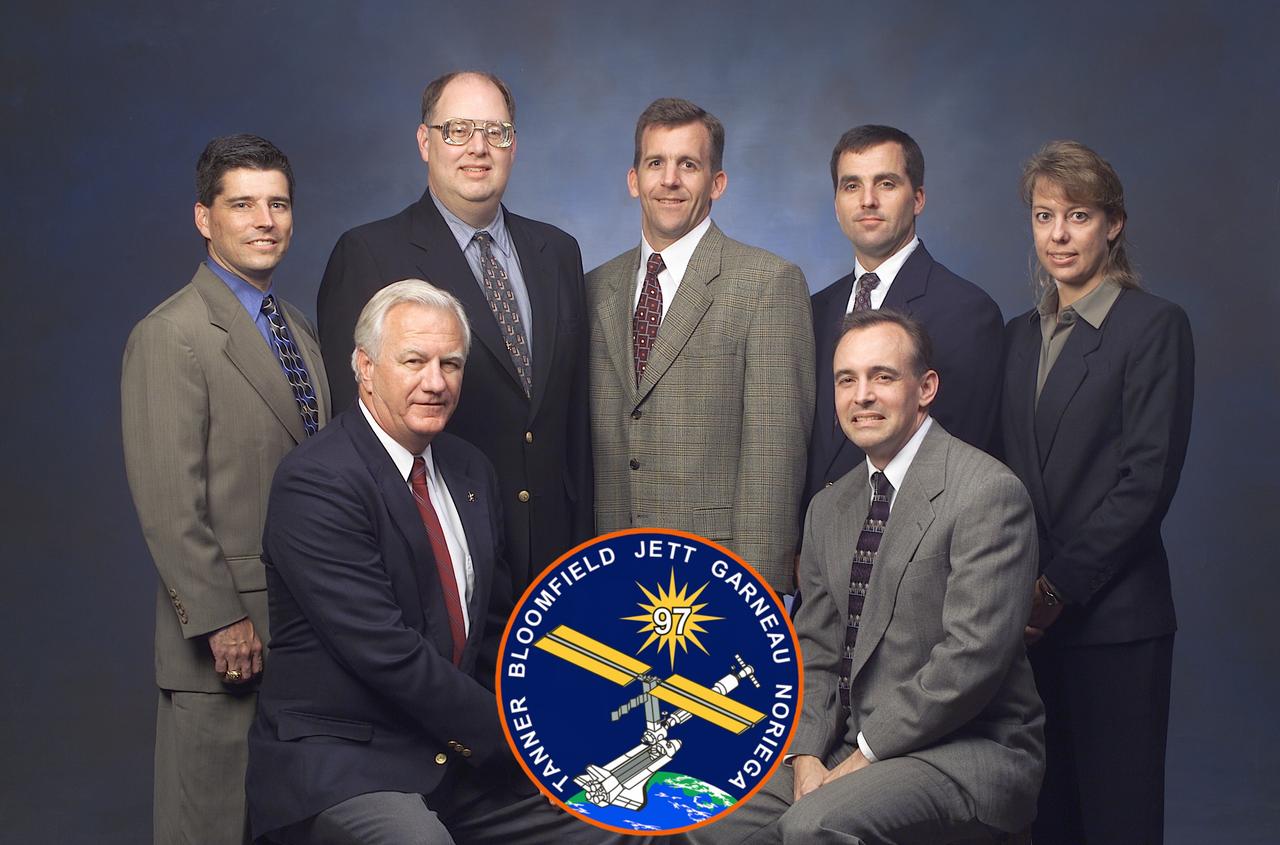 JSC2000-E-29413 (November 2000) --- Flight directors (FD) for the STS-97 mission pose for a pre-flight group portrait with the mission's insignia. Front row: Lead FD Bill Reeves (left), and Jeff Hanley. Back row, from the left: John Curry, Wayne Hale, LeRoy Cain, Paul Hill and Kelly Beck.