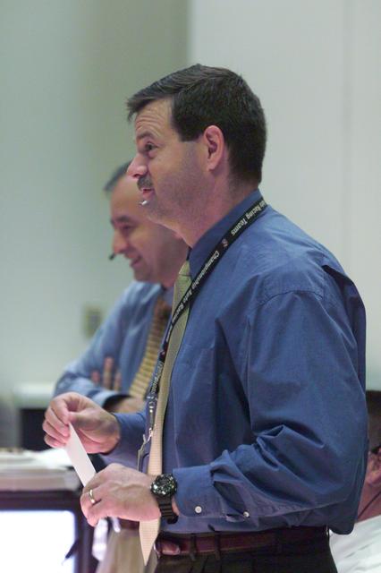 JSC2001-E-12122 (19 April 2001) --- Astronaut Scott D. Altman (foreground), STS-100 ascent spacecraft communicator (CAPCOM), stays on top of pre-launch activities at his console in the shuttle flight control room of Houston's Mission Control Center (MCC). Astronaut Mark L. Polansky stands beside Altman. Six astronauts and a cosmonaut, meanwhile, were strapped into their seats in the crew cabin of the Space Shuttle Endeavour several hundred miles away in Florida.
