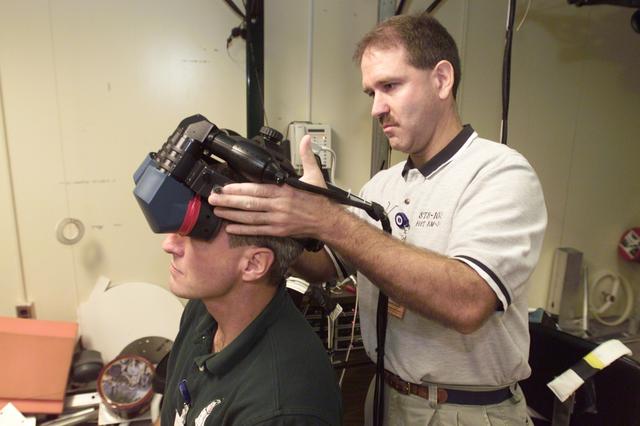 JSC2001-E-24460 (8 August 2001) --- John M. Grunsfeld (right),  payload commander,  assists Richard M. Linnehan, STS-109 mission specialist, in using virtual reality hardware at the Johnson Space Center (JSC) to rehearse some of his duties on the upcoming STS-109 mission, NASA&#0146;s fourth servicing visit to the Hubble Space Telescope (HST). They will join five other astronauts for the servicing mission, scheduled for February 2002.