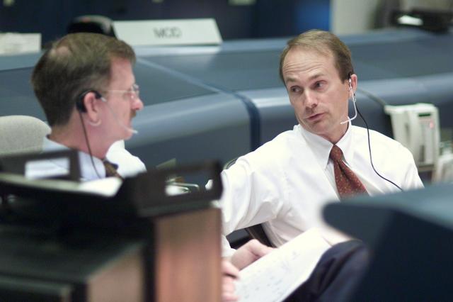JSC2001-E-25123 (16 August 2001) --- Astronauts Joseph R. Tanner (left) and Steve MacLean, both STS-105 spacecraft communicators (CAPCOM), discuss the progress of the extravehicular activity at their consoles in the shuttle flight control room (WFCR) in Houston’s Mission Control Center (MCC). At the time this photo was taken, mission specialists Daniel T. Barry and Patrick G. Forrester were performing the first of two scheduled space walks during Discovery’s voyage to the International Space Station (ISS). MacLean represents the Canadian Space Agency.