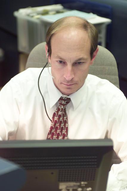 JSC2001-E-25422 (17 August 2001) --- Gary Ford, assembly and check-out officer, intently studies data at his console in the shuttle flight control room (WFCR) in Houston's Mission Control Center (MCC) during the STS-105 mission.