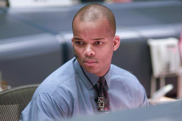 JSC2001-E-25473 (16 August 2001) --- Astronaut Robert L. Curbeam, Jr., spacecraft communicator (CAPCOM), monitors data at his console in the shuttle flight control room (WFCR) in Houston's Mission Control Center (MCC) during the STS-105 mission.