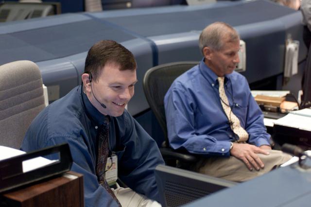 JSC2001-E-25513 (22 August 2001) --- Astronauts James M. Kelly (left) and Kenneth D. Cockrell, both spacecraft communicators (CAPCOM), monitor data at their consoles in the shuttle flight control room (WFCR) in Houston&#0146;s Mission Control Center (MCC). At the time this photo was taken the Space Shuttle Discovery was about to land at Kennedy Space Center, Florida, to mark the end of a successful mission to the International Space Station (ISS).