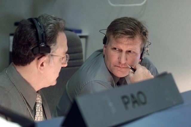 JSC2001-E-25518 (22 August 2001) --- Rob Navias (left), Public Affairs Officer (PAO), and Dan Carpenter, director of the Public Affairs Office, are photographed at their consoles in the shuttle flight control room (WFCR) in Houston&#0146;s Mission Control Center (MCC). At the time this photo was taken the Space Shuttle Discovery was about to land at Kennedy Space Center, Florida, to mark the end of a successful mission to the International Space Station (ISS).