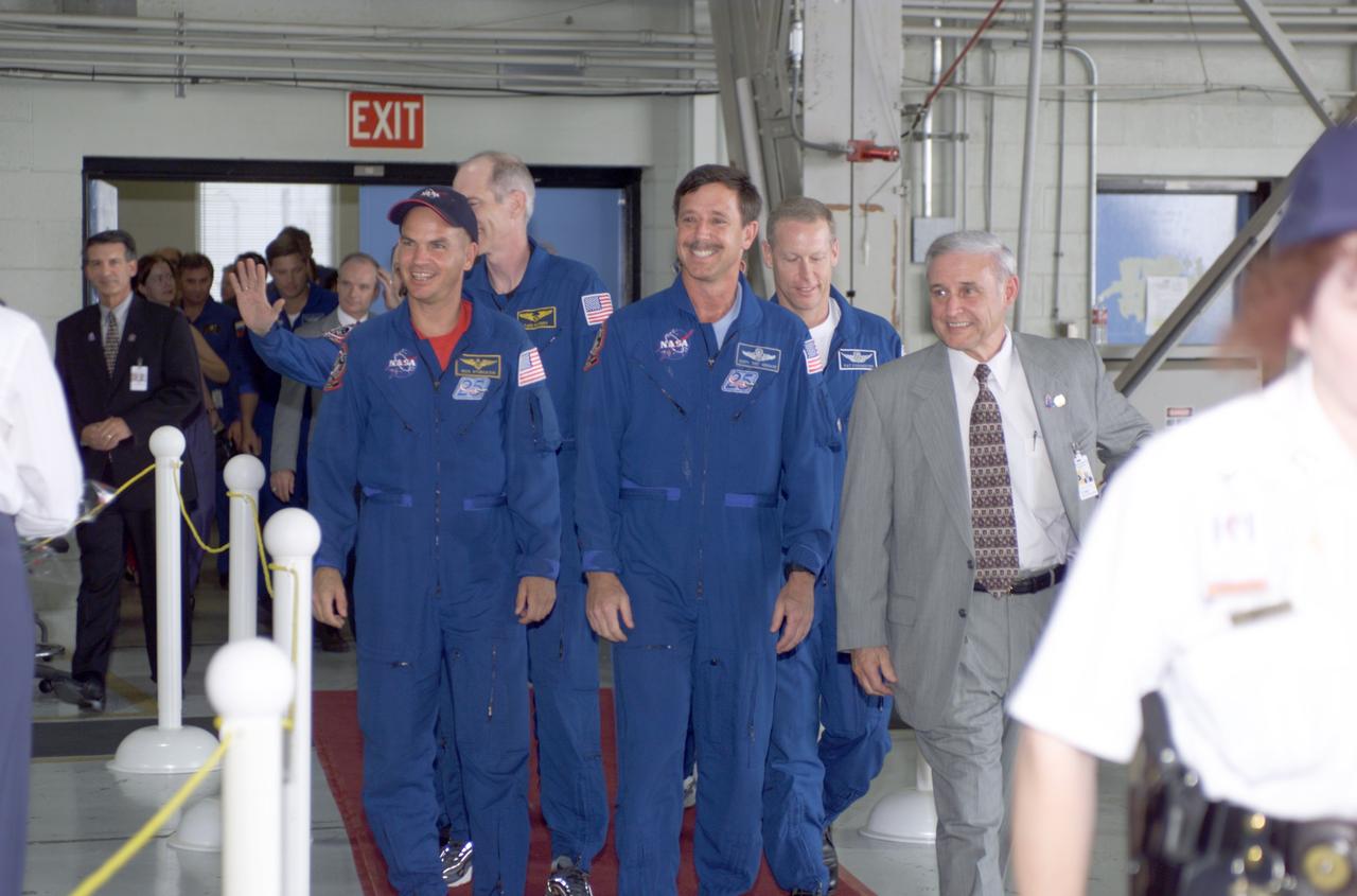 JSC2001-E-25810 (23 August 2001) --- The STS-105 crew and Johnson Space Center's (JSC) Acting Director Roy Estess enter Hangar 990 at Ellington Field during the STS-105 and Expedition Two crew return ceremonies. Among the group are: front row - Frederick W. Sturckow, pilot, Scott J. Horowitz, commander, and Estess; back row - Daniel T. Barry and Patrick G. Forrester, both mission specialists. The STS-105 crew delivered the Expedition Three crew and supplies to the International Space Station (ISS) and brought the Expedition Two crew back to Earth.