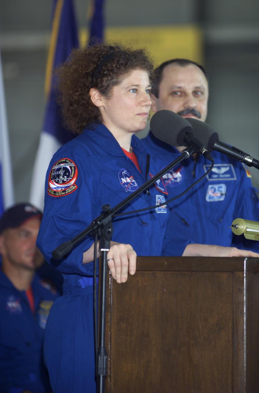 JSC2001-E-25813 (23 August 2001) --- Susan J. Helms, Expedition Two flight engineer, speaks from the podium in Hangar 990 at Ellington Field during the STS-105 and Expedition Two crew return ceremonies. Yury V. Usachev of Rosaviakosmos, Expedition Two mission commander, stands to Helms' left. Helms, Usachev and fellow Expedition Two crewmember James S. Voss spent five months aboard the International Space Station (ISS).