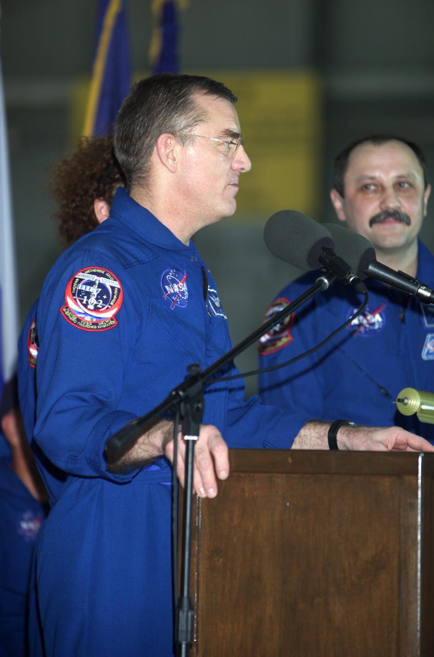JSC2001-E-25814 (23 August 2001) --- James S. Voss, Expedition Two flight engineer, speaks from the podium in Hangar 990 at Ellington Field during the STS-105 and Expedition Two crew return ceremonies. Yury V. Usachev of Rosaviakosmos, Expedition Two mission commander, stands to Voss' left. Voss, Usachev and fellow Expedition Two crewmember Susan J. Helms spent five months aboard the International Space Station (ISS).