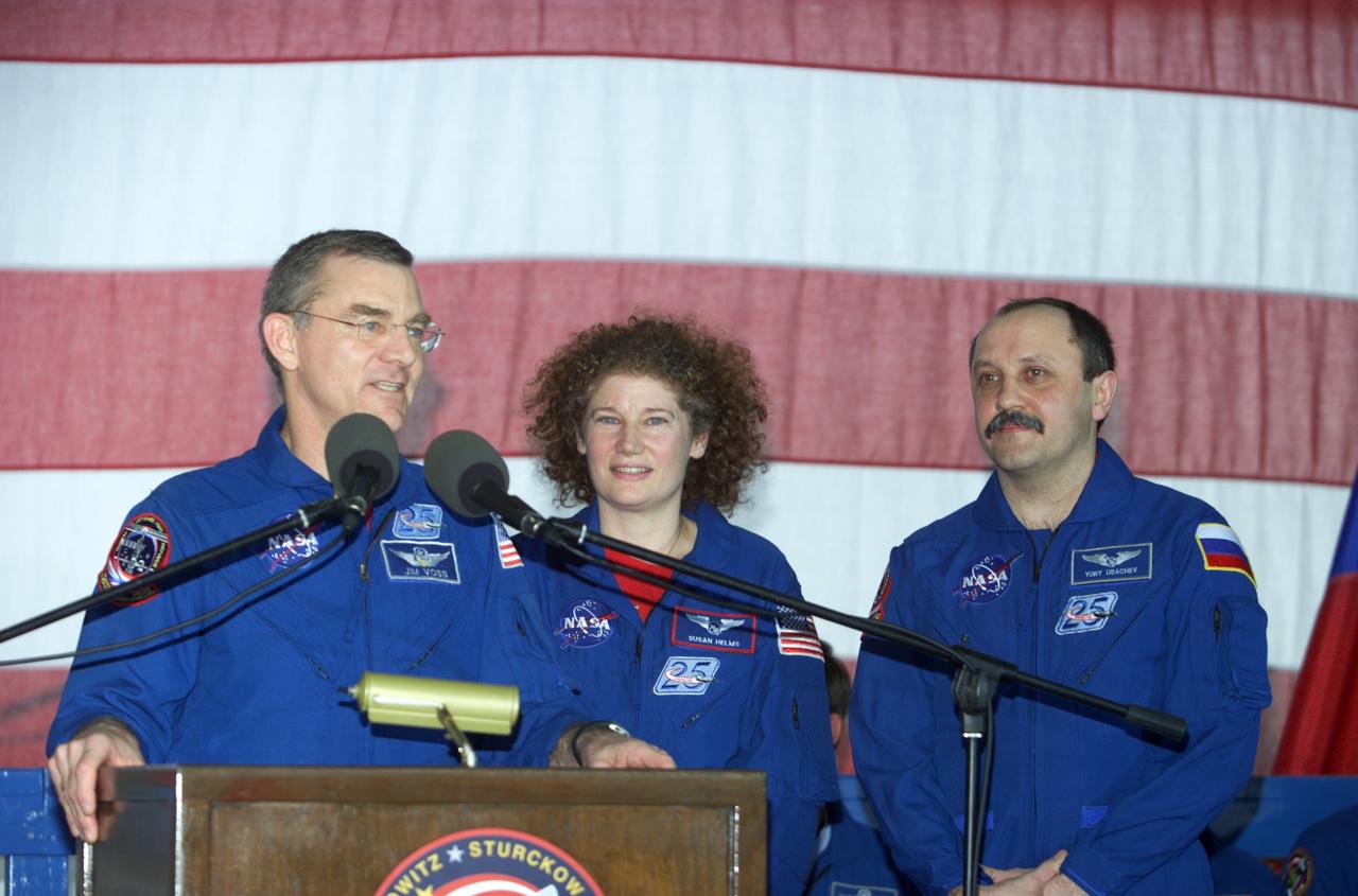 JSC2001-E-25815 (23 August 2001) --- The Expedition Two crew consisting of James S. Voss (left) and Susan J. Helms, flight engineers, and cosmonaut Yury V. Usachev, mission commander, field questions at the podium in Hangar 990 at Ellington Field during the STS-105 and Expedition Two crew return ceremonies. Voss, Helms and Usachev spent five months aboard the International Space Station (ISS).