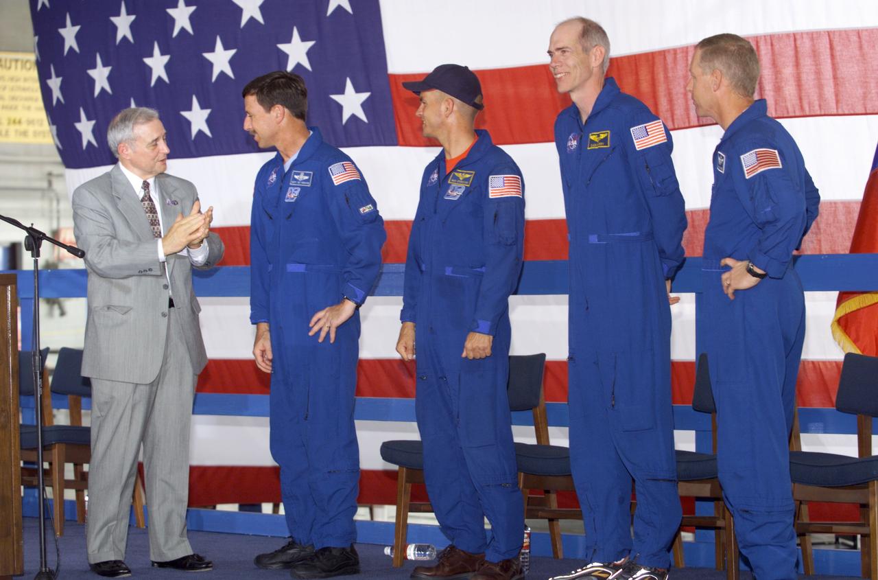 JSC2001-E-25821 (23 August 2001) --- Johnson Space Center's (JSC) Acting Director Roy Estess congratulates the STS-105 crew on the stage in Hangar 990 at Ellington Field during the STS-105 and Expedition Two crew return ceremonies. From left to right are Estess, Scott J. Horowitz, STS-105 commander, Frederick W. Sturckow, pilot, Daniel T. Barry, mission specialist, and Patrick G. Forrester, mission specialist. The STS-105 crew delivered the Expedition Three crew and supplies to the International Space Station (ISS) and brought the Expedition Two crew back to Earth.
