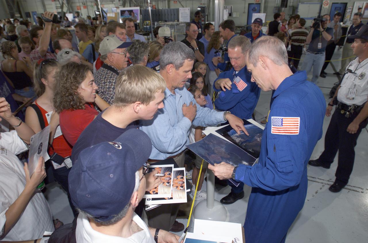JSC2001-E-25822 (23 August 2001) --- Daniel T. Barry (foreground) and Patrick G. Forrester, STS-105 mission specialists, sign autographs for the assembled crowd in Hangar 990 at Ellington Field during the STS-105 and Expedition Two crew return ceremonies. The STS-105 crew delivered the Expedition Three crew and supplies to the International Space Station (ISS) and brought the Expedition Two crew back to Earth.