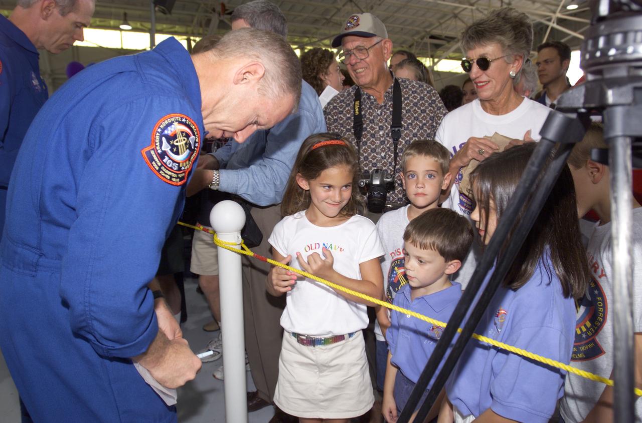 JSC2001-E-25823 (23 August 2001) --- Patrick G. Forrester (foreground) and Daniel T. Barry, STS-105 mission specialists, sign autographs for the assembled crowd in Hangar 990 at Ellington Field during the STS-105 and Expedition Two crew return ceremonies. The STS-105 crew delivered the Expedition Three crew and supplies to the International Space Station (ISS) and brought the Expedition Two crew back to Earth.