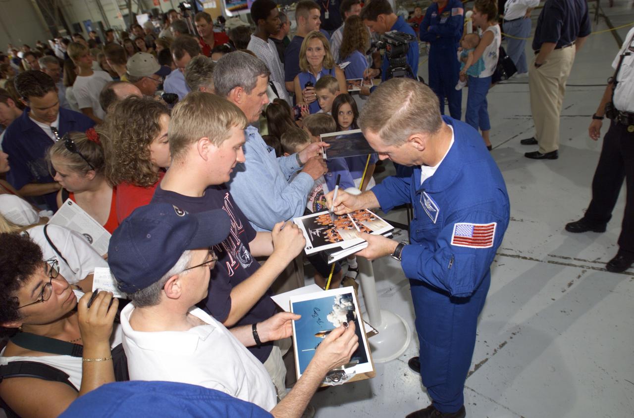 JSC2001-E-25824 (23 August 2001) --- Patrick G. Forrester, STS-105 mission specialist, signs autographs for the assembled crowd in Hangar 990 at Ellington Field during the STS-105 and Expedition Two crew return ceremonies. The STS-105 crew delivered the Expedition Three crew and supplies to the International Space Station (ISS) and brought the Expedition Two crew back to Earth.