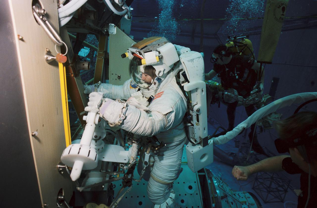 JSC2002-00507 (15 January 2002) --- Astronaut Philippe Perrin, STS-111 mission specialist, wears a training version of the Extravehicular Mobility Unit (EMU) space suit during an underwater simulation of extravehicular activity (EVA) scheduled for the 14th shuttle mission to the International Space Station (ISS). Perrin, representing CNES, the French Space Agency, was joined by astronaut Franklin R. Chang-Diaz (out of frame) for the simulation, conducted in the Neutral Buoyancy Laboratory (NBL) near the Johnson Space Center.