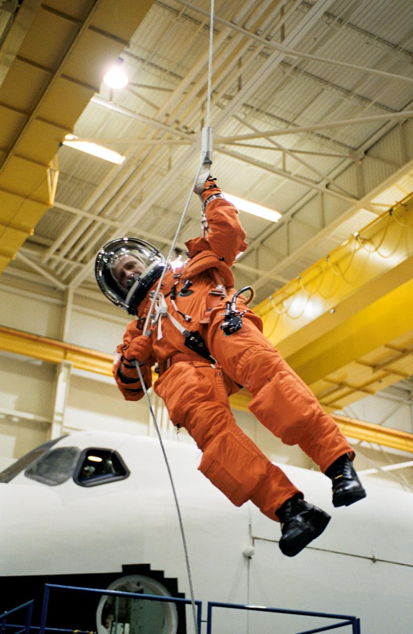 JSC2002-00688 (25 March 2002) --- Astronaut Christopher J. (Gus) Loria, STS-113 pilot, wearing a training version of the full-pressure launch and entry suit, lowers himself from a simulated shuttle in trouble during an emergency egress training session in the Space Vehicle Mockup Facility at the Johnson Space Center (JSC). STS-113 will be the 16th shuttle mission to visit the International Space Station (ISS).