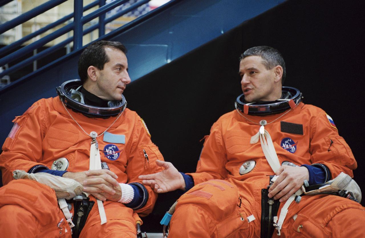 JSC2002-00721 (29 March 2002) --- Astronaut Philippe Perrin (left) and cosmonaut Valeri G. Korzun, STS-111 mission specialist and Expedition Five mission commander, respectively, attired in training versions of the shuttle launch and entry suit, await a mission training session in the Space Vehicle Mockup Facility at the Johnson Space Center (JSC). Perrin represents CNES, the French Space Agency, and Korzun represents Rosaviakosmos.