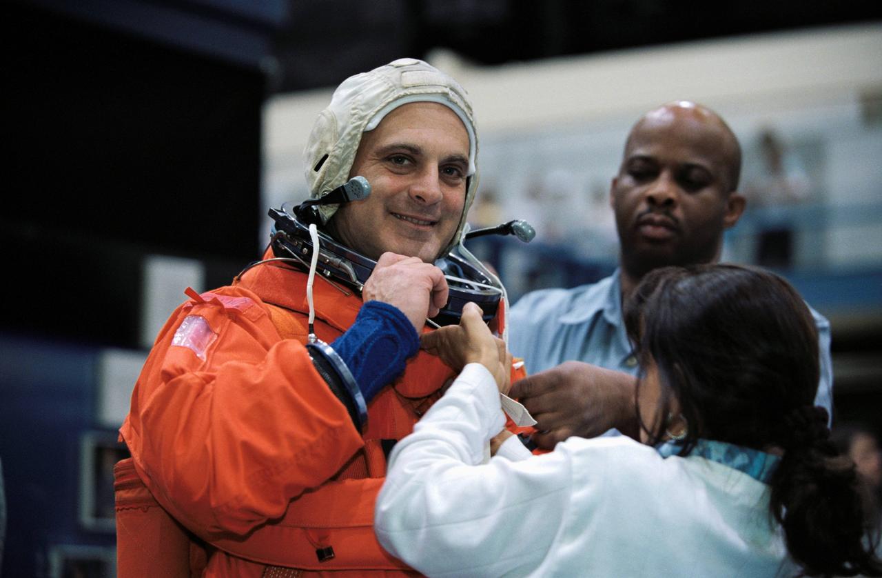 JSC2002-00869 (24 April 2002) --- Astronaut David A. Wolf, STS-112 mission specialist, gets help with final touches on the training version of the full-pressure launch and entry suit as he prepares for the start of a mission training session in the Space Vehicle Mockup Facility at the Johnson Space Center (JSC).