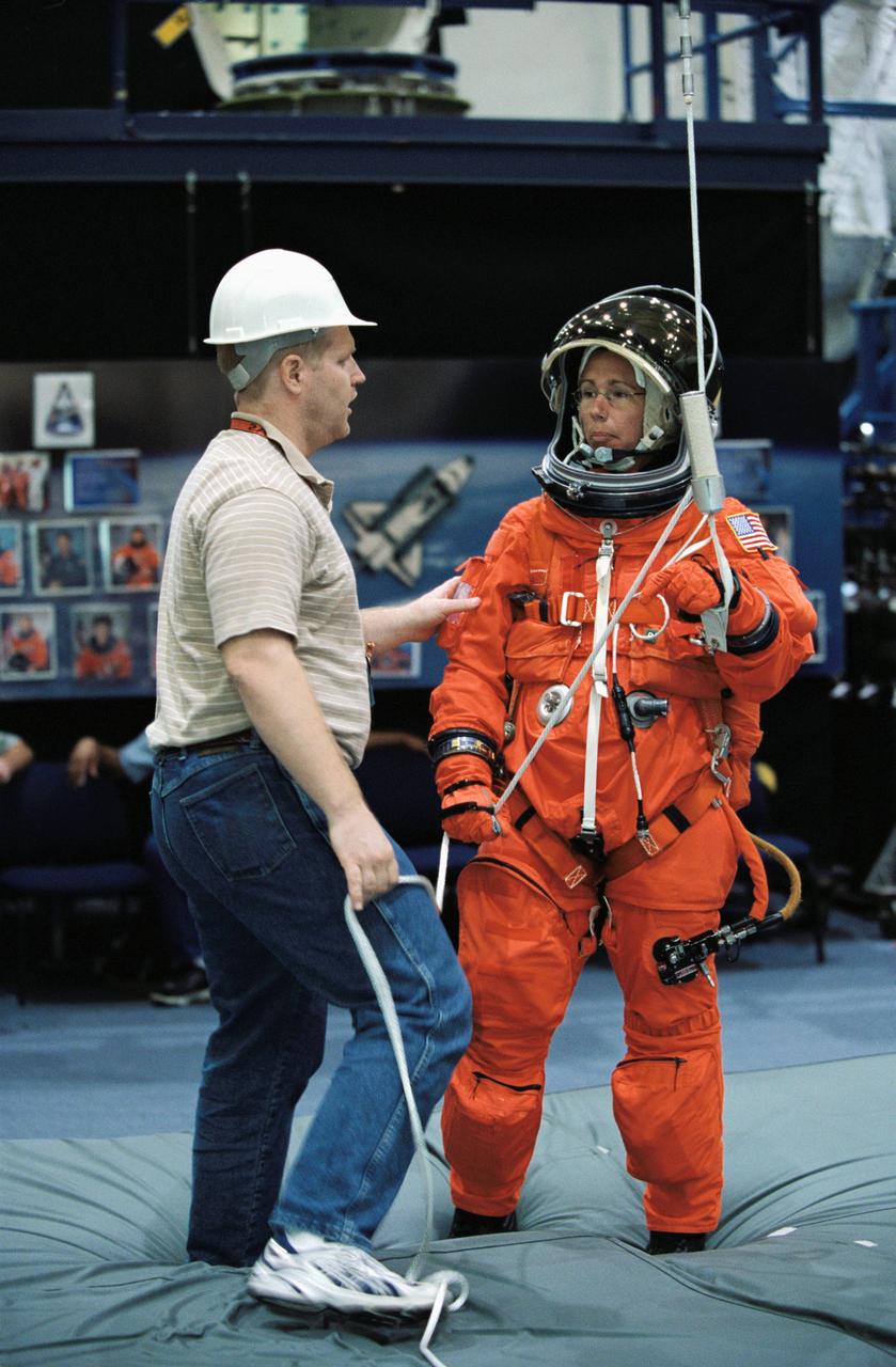 JSC2002-00878 (24 April 2002) --- Astronaut Sandra H. Magnus, STS-112 mission specialist, is briefed by United Space Alliance (USA) crew trainer Bob Behrendsen on the usage of the Sky-genie, used to lower oneself from a troubled shuttle. The briefing came during a training session in the Space Vehicle Mockup Facility at the Johnson Space Center (JSC). Magnus is wearing a training version of the shuttle launch and entry suit.