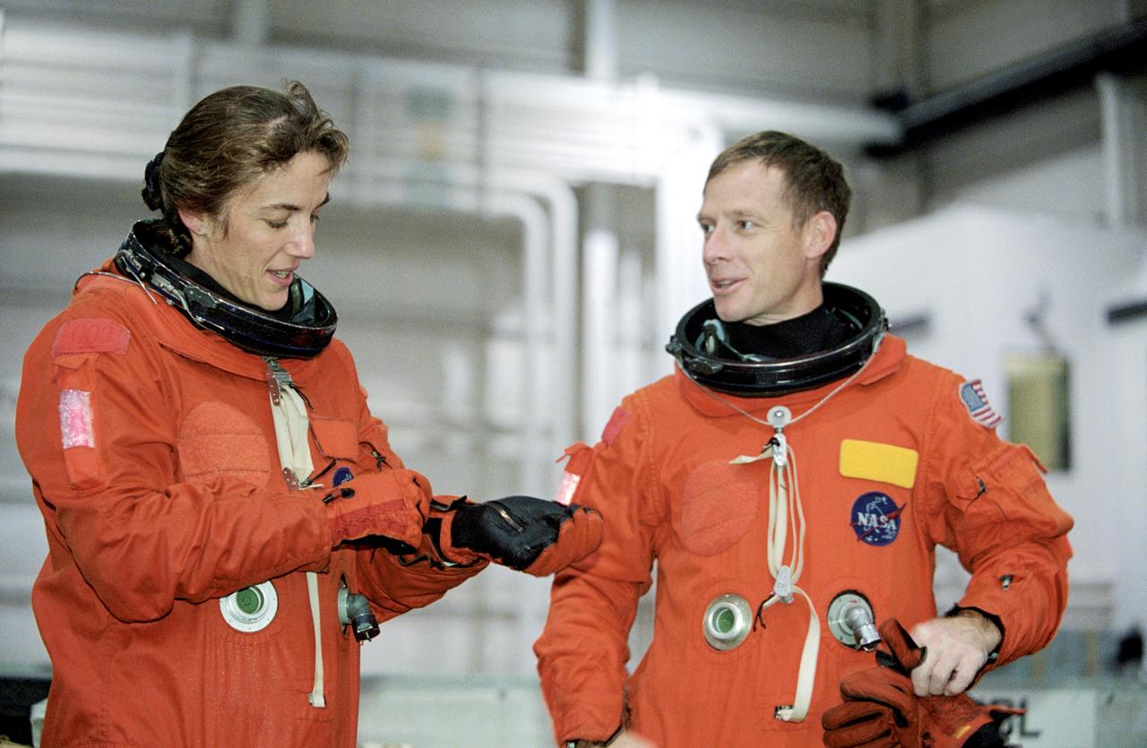 JSC2002-01914 (21 October 2002) --- Astronauts Heidemarie M. Stefanyshyn-Piper (left) and Christopher J. Ferguson, STS-115 mission specialist and pilot, respectively, don training versions of the full-pressure launch and entry suit prior to the start of a training session in the Neutral Buoyancy Laboratory (NBL) near the Johnson Space Center (JSC).