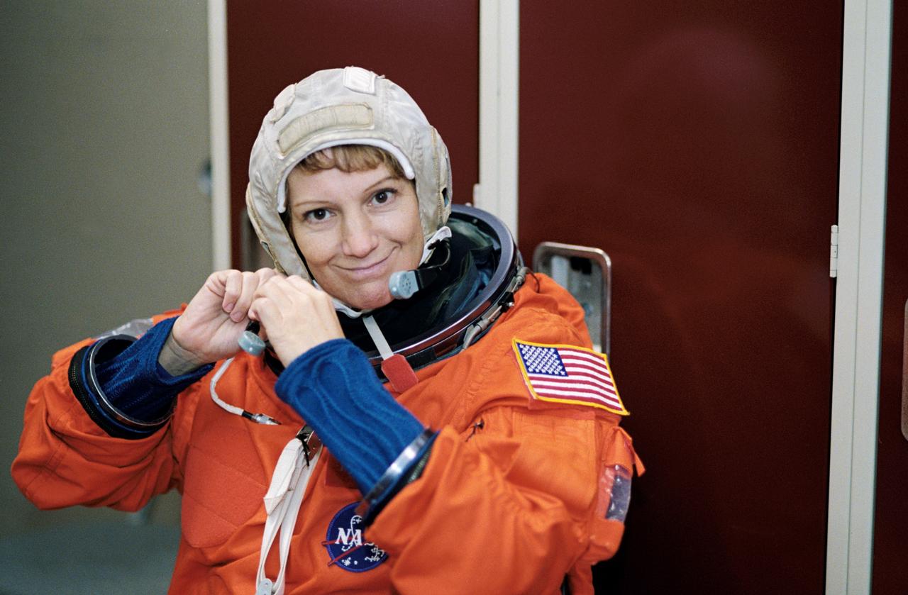 JSC2002-02001 (12 November 2002) --- Astronaut Eileen M. Collins, STS-114 mission commander, dons a training version of the full-pressure launch and entry suit prior to the start of a training session in the Space Vehicle Mockup Facility at the Johnson Space Center (JSC).