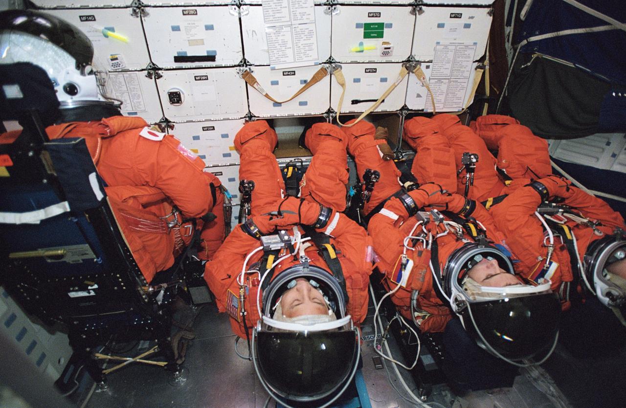 JSC2002-02022 (13 November 2002) --- Astronauts Soichi Noguchi (left), STS-114 mission specialist; Edward T. Lu, Expedition Seven flight engineer; cosmonauts Yuri I. Malenchenko, Expedition Seven mission commander; and Alexander Y. Kaleri, Expedition Seven flight engineer; participate in mission training in one of the full-scale trainers in the Space Vehicle Mockup Facility at the Johnson Space Center (JSC). Attired in training versions of the shuttle launch and entry suit, the four are seated on the middeck for an emergency egress training session. Noguchi represents Japan’s National Space Development Agency (NASDA). Malenchenko and Kaleri represent Rosaviakosmos.