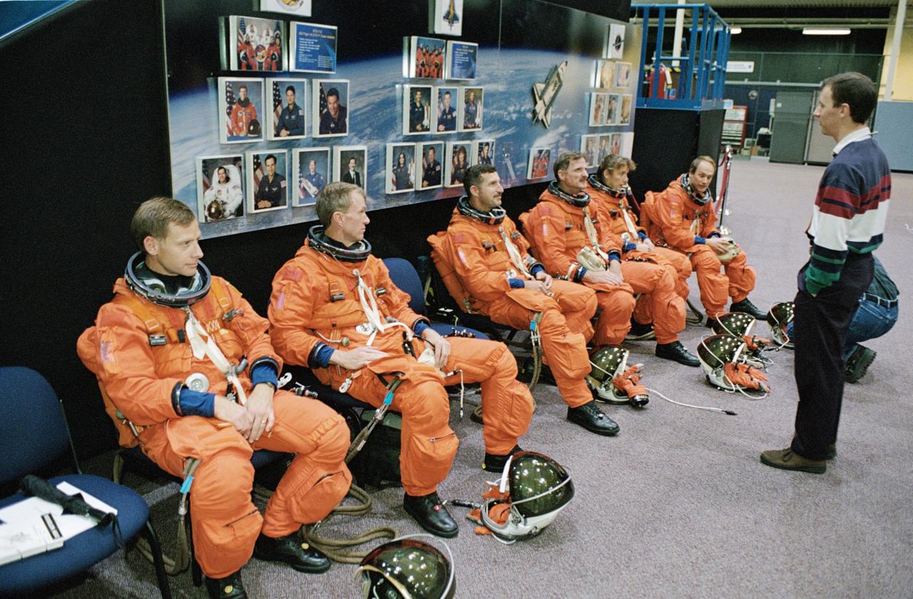 JSC2002-02126 (3 December 2002) --- Members of the STS-115 crew are briefed by United Space Alliance (USA) crew trainer David Pogue (standing) during an emergency egress training session in the Space Vehicle Mockup Facility at the Johnson Space Center (JSC).  From the left are astronauts Christopher J. Ferguson, Brent W. Jett, Jr., pilot and mission commander, respectively; Daniel C. Burbank, Joseph R. (Joe) Tanner, Heidemarie M. Stefanyshyn-Piper, and Steven G. MacLean, all mission specialists. The crew is wearing training versions of the shuttle launch and entry suit. MacLean represents the Canadian Space Agency.