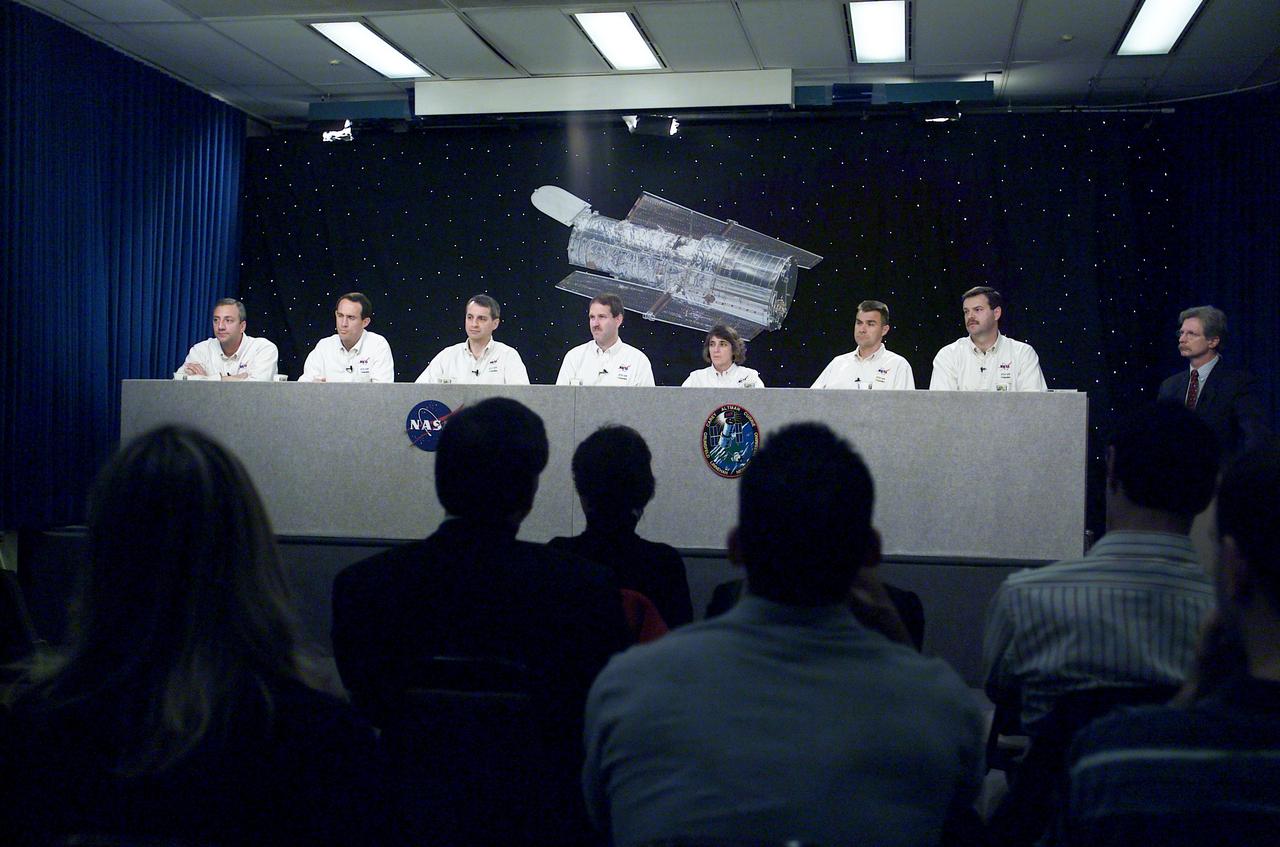 JSC2002-E-05104 (15 February 2002) --- The STS-109 crewmembers are photographed during a pre-flight press conference at Johnson Space Center (JSC). From the left are astronauts Michael J. Massimino, James H. Newman, Richard M. Linnehan, John M. Grunsfeld, Nancy J. Currie, Duane G. Carey, and Scott D. Altman. Altman and Carey are mission commander and pilot, respectively. Grunsfeld is payload commander and Currie, Linnehan, Newman and Massimino are mission specialists.