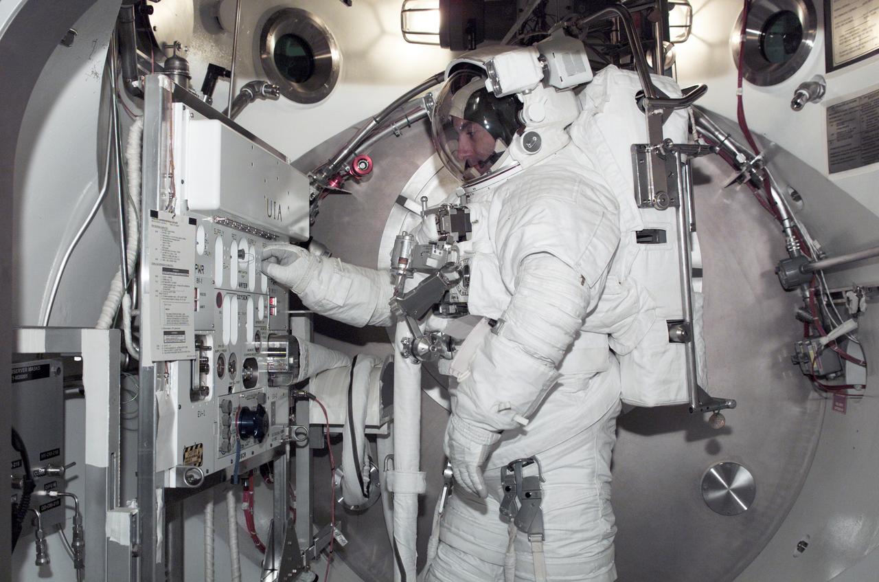 JSC2002-E-08243 (20 February 2002) --- Astronaut Philippe Perrin, STS-111 mission specialist representing CNES, the French Space Agency, is photographed during an Extravehicular Mobility Unit (EMU) fit check in a Space Station Airlock Test Article (SSATA) in the Crew Systems Laboratory at the Johnson Space Center (JSC).