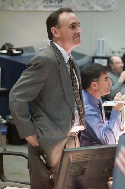 JSC2002-E-08460 (7 March 2002) --- Flight directors Jeff Hanley (standing) and Bryan P. Austin watch the large screens from their consoles in the shuttle flight control room (WFCR) in Houston;s Mission Control Center (MCC) during the STS-109 Hubble Space Telescope (HST) servicing mission.